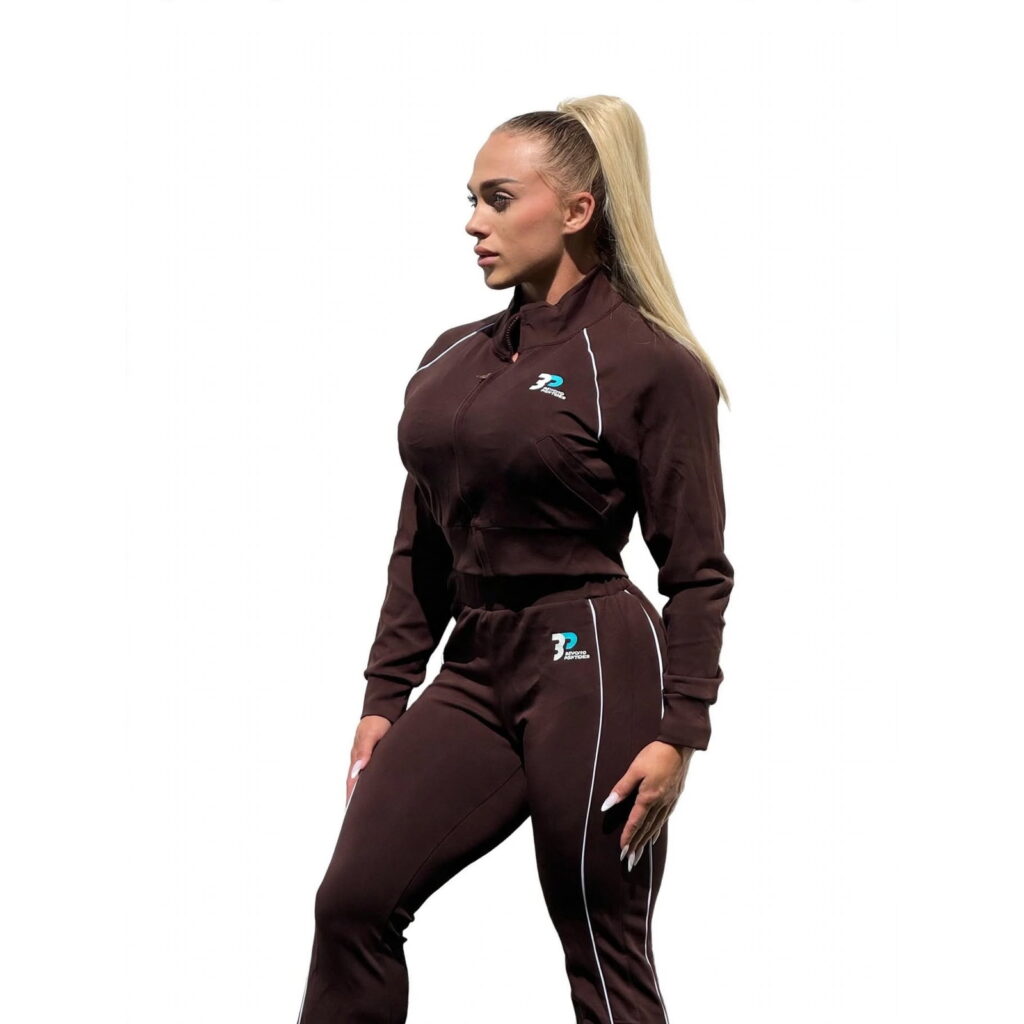 Beyond Peptides women's tracksuit in dark brown, side view showing the white piping