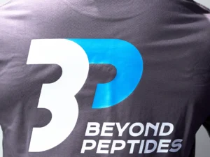 Close-up of the large Beyond Peptides print on the back of the Grey Oversized Tee