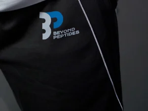 Close-up of the Beyond Peptides logo and the grey piping on the left thigh of the Grey Unisex Jogger