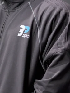 Close-up of the stand collar, zip, chest logo, grey piping and sleeve stripes of the Grey Unisex Zipper