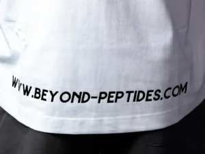 Close-up of the double-stitched hem and the web address print on the back of the White Oversized Tee