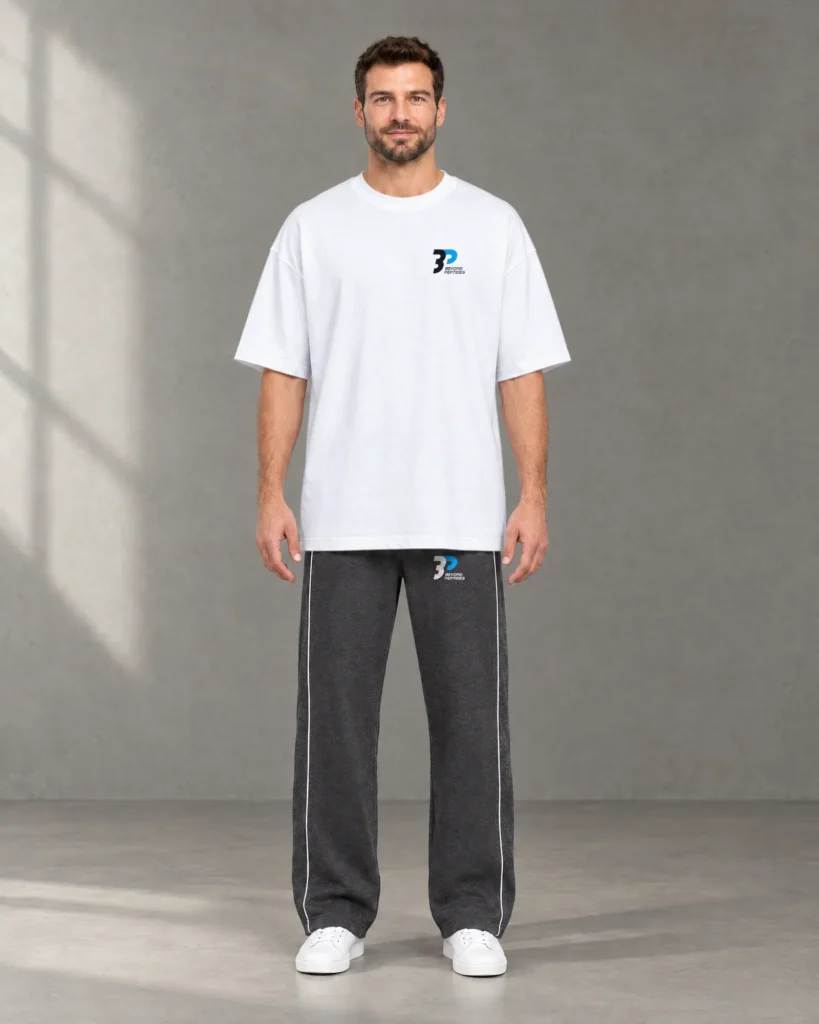 Model in the White Oversized Tee and the Grey Unisex Jogger in a studio, front view