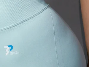 Close-up photo of the ribbed waistband and the logo on the left hip of the arctic blue Women's Leggings